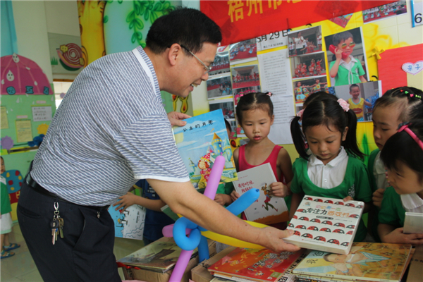 梧州市總工會黨組書記、常務(wù)副主席朱明勝在梧州市總工會到梧州高新區(qū)雙語實驗學校開展關(guān)愛農(nóng)民工留守活動中為孩子們送上學習用具